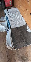 Opened bundle of IKO Cambridge shingles partly wrapped