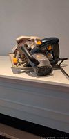 Left side profile of Ryobi circular saw showing handle, motor housing and cord