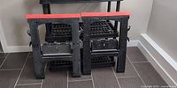Front view of both black plastic sawhorses with red tops