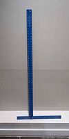 Full view of blue aluminum T-square standing upright