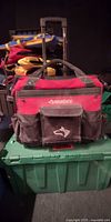 Front view of Husky red/black rolling tool bag on plastic bin