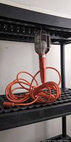 Full view of handheld work light coiled on shelf