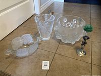 Group view of four crystal pieces: vase, two bowls, crystal rose