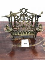 Front view showing full brass menorah, candle holders, decorative backplate