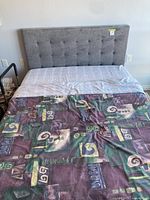 Front view of grey tufted headboard and mattress