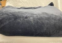Folded thick black blanket showing plush texture