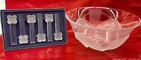 Crystal bowl beside boxed set of six frosted crystal cutlery rests on red backdrop