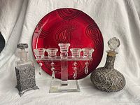 Group view of both decanters, red charger, and glass candleholder