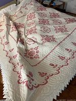 Full view of quilt on queen bed showing pattern, size, scalloped edge