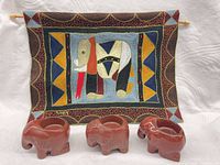 Front view of embroidered wall hanging with three elephant candle holders