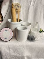 Group shot showing all items: crock with rolling pin, three planters, candle tin, packaged pig shakers