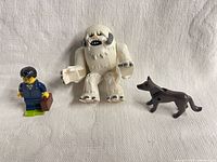 Wampa creature, businessman minifigure and dog displayed on white background