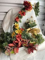 Overall view of decorated garland, plain garland, metal candle centerpiece, gold pedestal