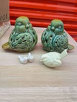 Group shot of two green lovebird luminaries and three smaller bird figurines