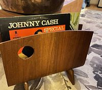 Front view of teak bentwood magazine rack with record inserted for scale