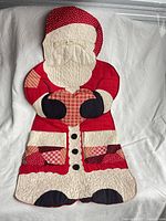 Front view showing Santa shape, quilted details, pockets