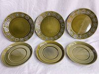 Front view of three side plates with geometric relief pattern and three plain-rim saucers, olive green ceramic.