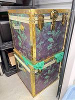 Two stacked fern-print trunks showing overall design and hardware