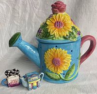 Front view of sunflower teapot with two Wade mini teapots