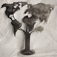 Front view of steel world map tree sculpture on base