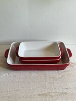Three red and white KitchenAid stoneware baking dishes stacked