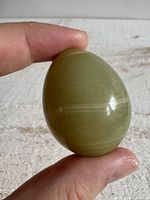 Front view of green polished stone egg showing colour and bands