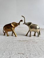 Front angled view of both brass elephant figurines showing size and form