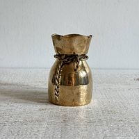 Front view of brass bag-shaped vase with rope wrap