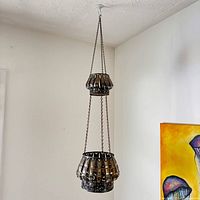 Full view of two-tier hanging metal planter suspended from ceiling