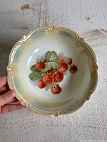 Top view of porcelain bowl showing strawberry motif and scalloped rim