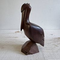 Left side view of carved ironwood pelican on base