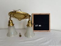 Full view of brass ceiling light with both shades and finial shown