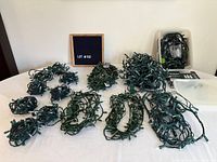 Overall view of eight coiled string lights on table with boxed Noma set