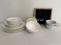 Stack of Roscher plates, bowls, two Trudeau baking dishes