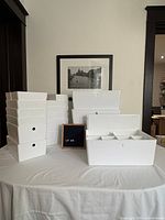 Assorted white storage bins stacked and displayed