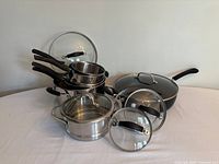 Group shot of all cookware pieces showing pots, lids, steamer baskets and skillet