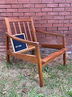 Front angled view of wood lounge chair frame showing arms, seat support, and backrest