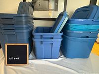 Full view showing three stacks of blue plastic storage totes with lids
