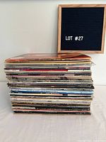 Stack of approximately 50 vinyl records with message board beside