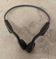 Front view of dark gray bone-conduction headphones showing overall form