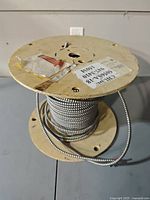 Overall view of wooden spool with armored cable and specification label