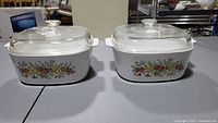 Front view of both Spice of Life casserole dishes with lids on tabletop