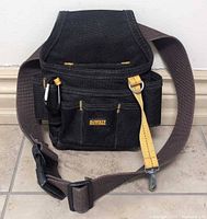 Front view of DeWALT tool pouch showing pockets, strap, D-ring, carabiner