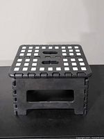 Top view of folded plastic step stool showing anti-slip dots and carry handle