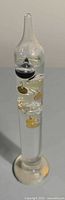 Full view of glass Galileo thermometer standing upright