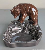 Front view of glazed ceramic bear ashtray showing bear over pool with fish
