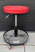 Front view showing red padded seat, gas lift post, tray base, casters