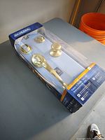 Boxed Schlage polished brass front entry handle set showing contents