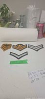 All four embroidered rank patches arranged on table