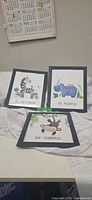 Group shot of three framed cartoon animal prints